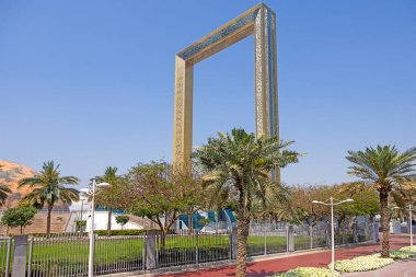 Dubai Çerçeve Anıtı Gün boyunca palmiye ağaçları ve mavi gökyüzü