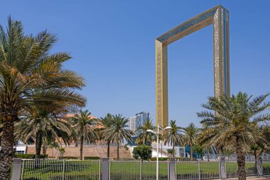 Dubai Çerçeve Anıtı Gün boyunca palmiye ağaçları ve mavi gökyüzü