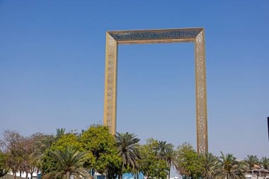 Dubai Çerçeve Anıtı Gün boyunca palmiye ağaçları ve mavi gökyüzü