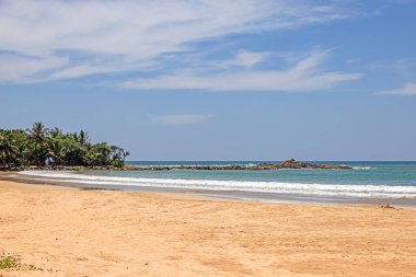 Yaz aylarında ada kayaları ve bereketli palmiye ormanlarıyla tropikal sahilde açık bir gün.