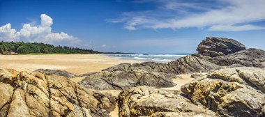 Yazın Sri Lanka 'da kayalar ve turkuaz okyanusla güneşli tropikal plajlar