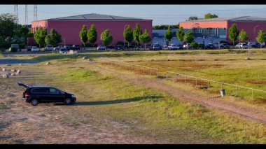 Dikey İHA yükselişi alacakaranlıkta ufuk çizgisini ve kasabayı gösteriyor.