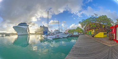 Büyük yolcu gemileri sakin suları ve dağınık bulutları olan parlak gökyüzü olan tropikal bir limana yanaştılar..