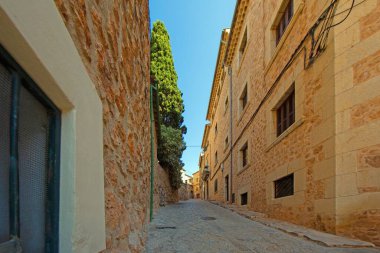 Majorcan köyünde taş evleri ve yeşil panjurları olan büyüleyici dar bir cadde.