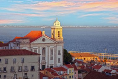 Lizbon Alfama bölgesindeki Aziz Stephen Kilisesi. Gün batımında nehir manzaralı.