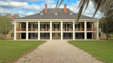 Koloni tarzı çiftlik evi. New Orleans 'a yakın sütunları var. Görünürde kimse yok.