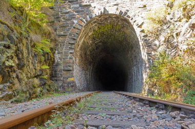 Thüringen Almanya 'sında karanlığa giden demiryolu hattının bulunduğu taştan tünelin alçak açılı görüntüsü