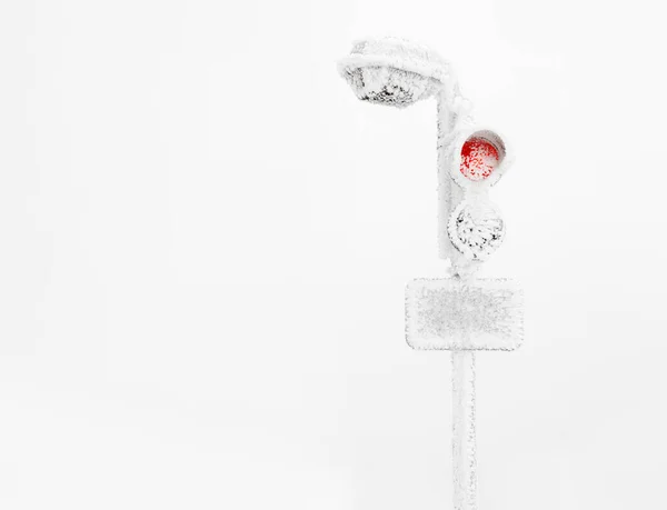 Lantern and street lights covered in ice and snow during a winter blizzard.