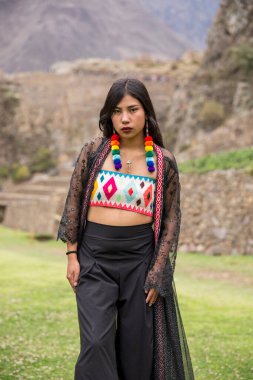 Genç And kızı Cusco Peru 'da Ollantaytambo' da poz veriyor. Peru 'dan halk kıyafetleri giyen genç bir latin manken. Cusco 'daki İnka döneminden geleneksel mimari.