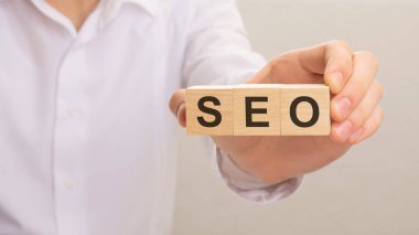 SEO metniyle ahşap küpleri tutan el. finans, yönetim, ekonomi, iş kavramı.