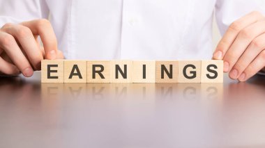 Küplerin inşası ve iş konseptiyle yapılmış EARNINGS kelimesi.