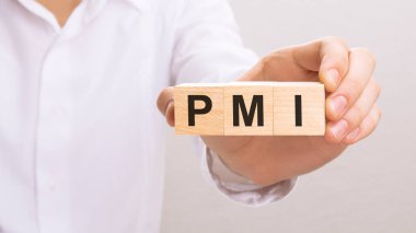 PMI metniyle ahşap küpleri tutan el. finans, yönetim, ekonomi, iş kavramı.