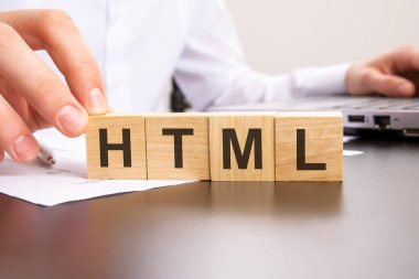Adam ofis masasının arka planında tahta bloklar olan HTML 'de haber yaptı. seçici odak.