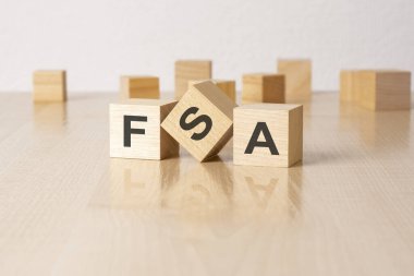 FSA - Gri arka planda harfleri olan ahşap blokların kısaltması. Tablonun aynalı yüzeyindeki yansıma başlığı.