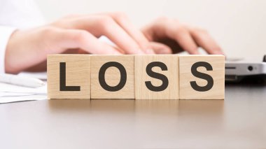 Bilgisayarda çalışan arka plandaki adamın tahta bloklarıyla kayıp haberi geldi. seçici odak.