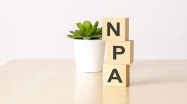 npa - text on wooden cubes on wooden background. business concept. clipart