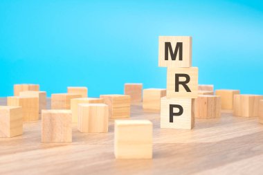 MRP - short for Marketing Research Planning - written on a wooden cube, business concept. blue background clipart