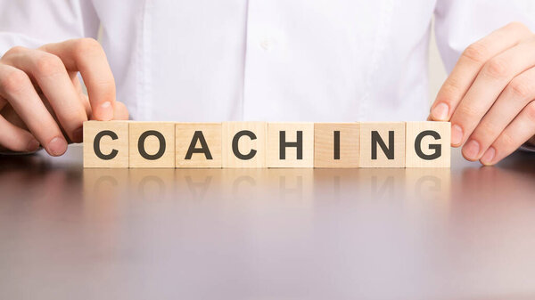 COACHING word made with building cubes, business concept.