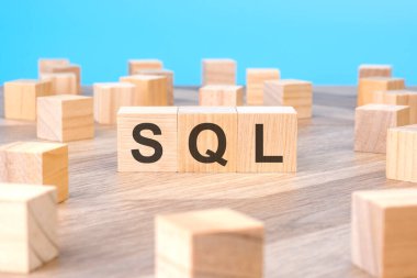Küp tahta bloklarda sembol olarak SQL metni, açık mavi arkaplan.