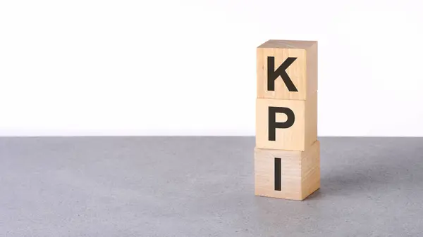 stock image Closeup of wooden blocks with word KPI - Key Performance Indicators - on gray table