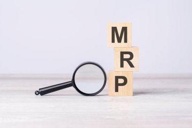 MRP - or Maximum Retail Price concept. text on wooden cubes under a magnifying glass. clipart