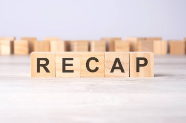 Kelime RECAP bir ışık masasının üzerinde duran tahta küplere kazınmış. iş kavramı.