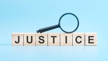 Üzerinde büyüteç olan tahta bloklar, JUSTICE. mavi arkaplan