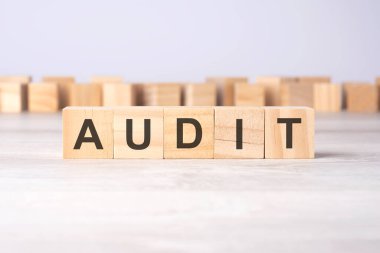 Işık masasında duran tahta küplere AUDIT yazılıydı. iş kavramı.