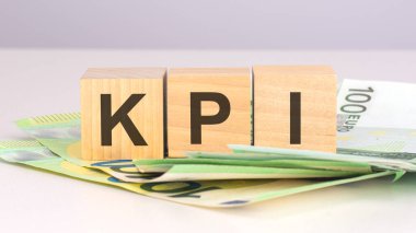 KPI - Anahtar Performans Göstergelerinin kısaltması. Avro banknotları olan tahta küplerle ilgili bir yazı. ön görünüm