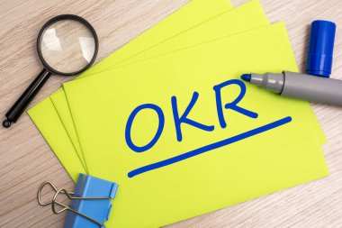OKR - Hedefler ve Anahtar Sonuçları - Sarı kart üzerinde mavi işaretli kısaltma metin kavramı