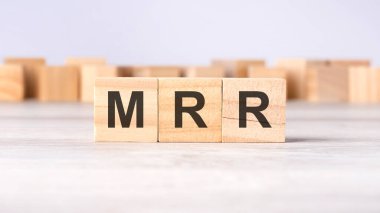 MRR - kısaltma kavramı açık gri arka planda tahta küplere veya bloklara yazıldı