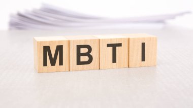 Tahta bloklara yazılmış mbti metni, arkaplanda beyaz çarşaf yığını