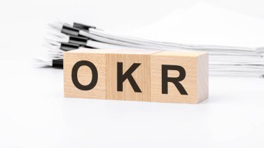Beyaz arka planda OKR tahta küpler kelimesi var. OKR - Hedefler ve Anahtar Sonuçları
