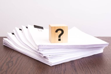 Tahta bloktaki soru işareti. Cevaplar arıyor, bir sorunu çözme düşünceleri, şüpheleri var. eğitim ve iş konsepti