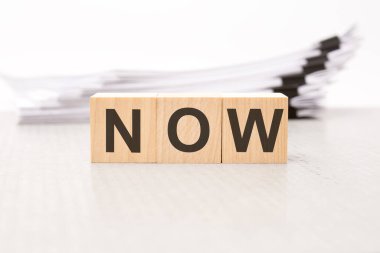 Şimdi, tahta bloklarda metin. Geçmişi bir iş belgesi. Finans kavramı. beyaz arkaplan