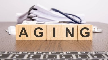 Tahta küpler, steteskop, hap, doktorun masaüstündeki not defteri, tıbbi konsept ile yaşlanma harflerini oluşturur.