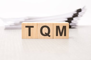 Tahta bloklarda tqm - metin. Geçmişi bir iş belgesi. Finans kavramı. beyaz arkaplan