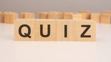 Beyaz arkaplanlı küçük tahta küplerin üzerinde kısa harfli İngilizce harfler - QUIZ -. kopyalama alanı konsepti. seçim odağı.