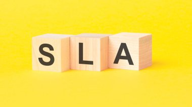 SLA - Hizmet Seviyesi Anlaşması - sarı arkaplanda tahta küplere yazılmış