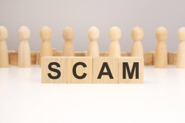 Dolandırıcılık - beyaz arkaplanda tahta küp harflerden oluşan kelime, metin için boşluk kopyala