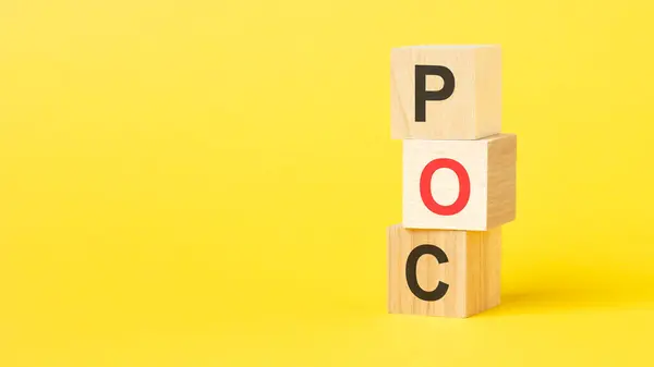POC - Proof of Concept symbol. wooden cubes with words POC. beautiful yellow background. business and POC concept