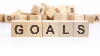 Beyaz arkaplanda yazı hedefleri olan tahta küp. Hedefler iş ve Yeni Yıl kavramları