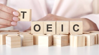 Tahta masada TOEIC sözcüğüyle ahşap blokları dizmek. Girişim ve girişimci konsepti. pazarlama