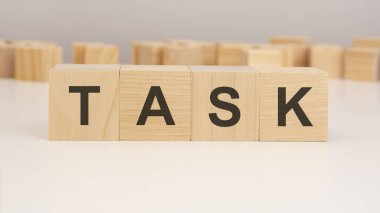 Beyaz arkaplanlı küçük tahta küplerin üzerinde TASK yazılı kısa kelime İngilizce harfleri. kopyalama alanı konsepti. seçim odağı