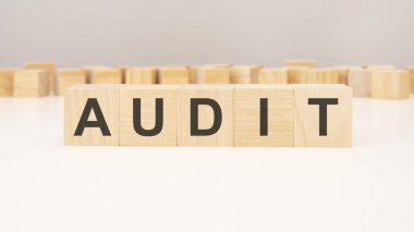 AUDIT, ahşap bloklardan ve gri arkaplanda farklı tahta bloklardan yapılmıştır.