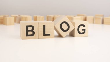 Seçici odaklanma. BLOG kelimesi tahta küp yapısına yazılmıştır. Parlak arkaplan üzerindeki bloklar