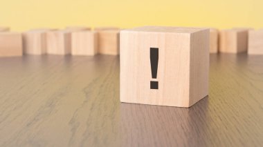 Tahta masanın üzerinde ünlem işareti olan tahta küp, yaklaş. Metin için boşluk