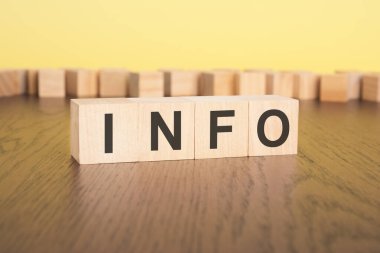 Küçük tahta bloklar üzerinde INFO yazılı kısa kelime İngilizce harfleri. kahverengi arka plan. seçim odağı.