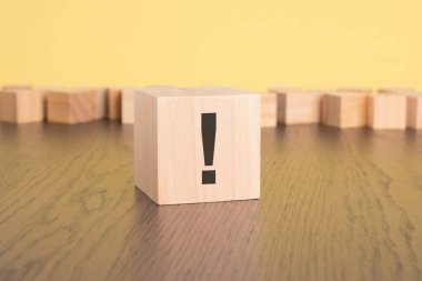 Tahta masanın üzerinde ünlem işareti olan tahta küp, yaklaş. Metin için boşluk