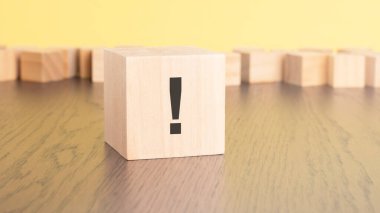 Tahta masanın üzerinde ünlem işareti olan tahta küp, yaklaş. Metin için boşluk